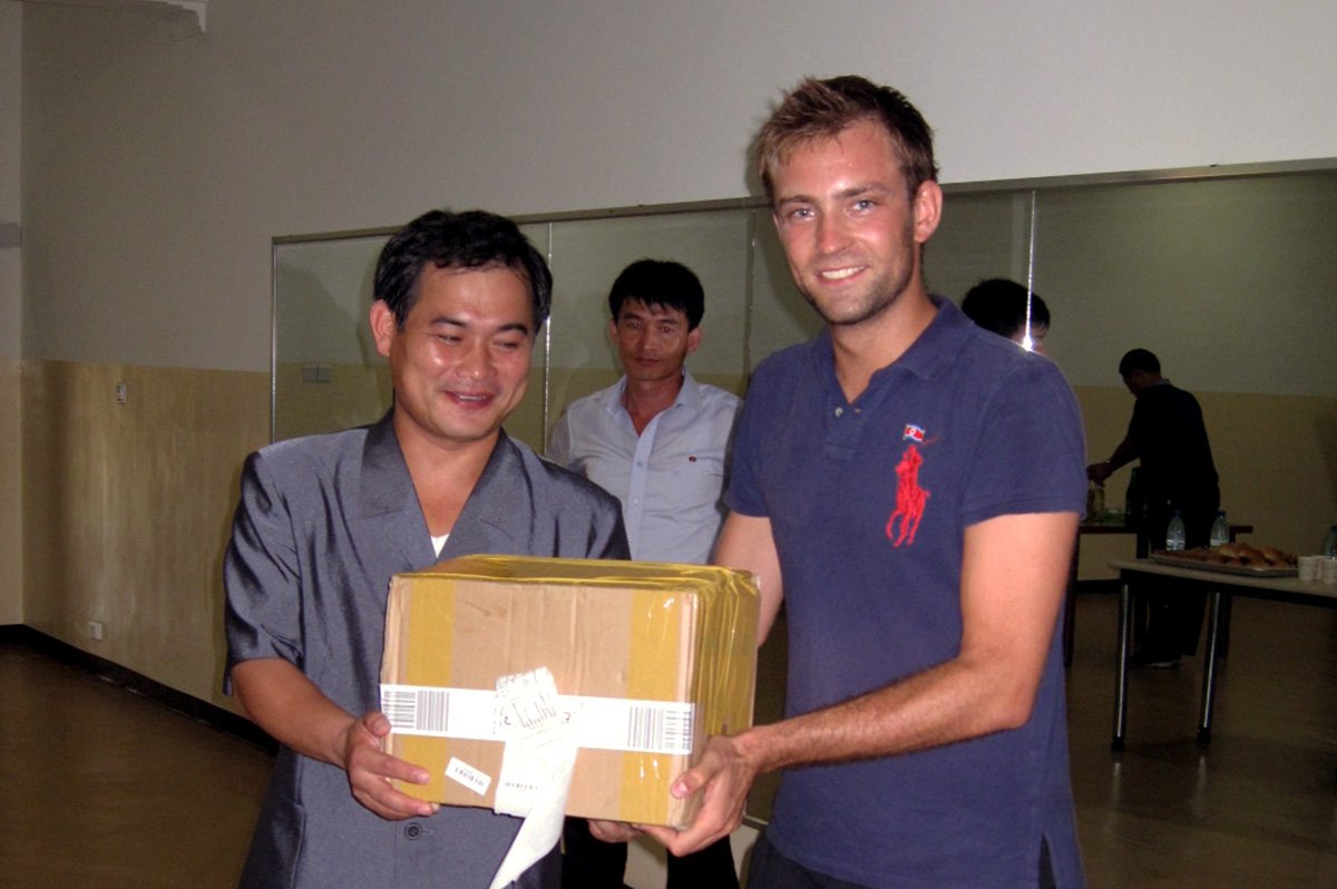 Robert Grund überreicht Kim Mun-Chol ein Paket.